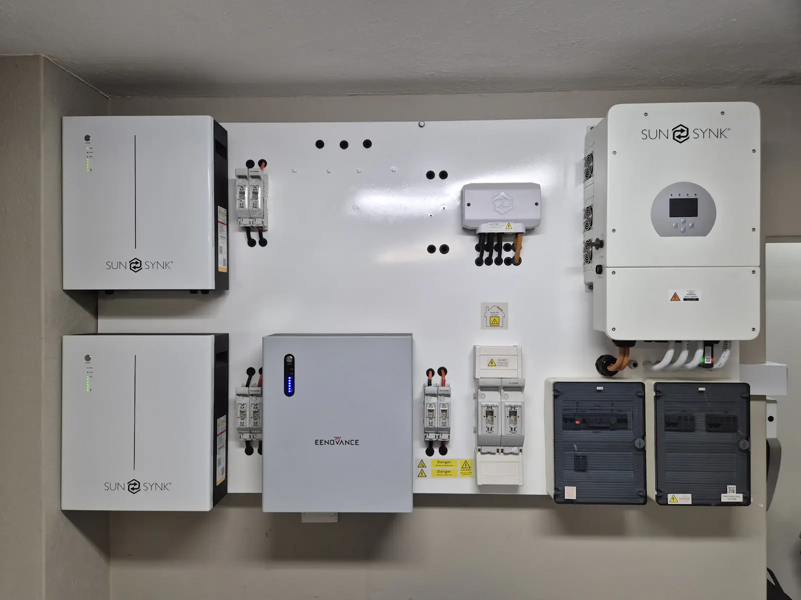 Bateria de parede, inversor e quadro de proteção instalados em uma parede